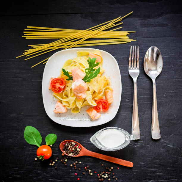 istock Pasta with salmon on dark background. Flat lay, top view. 803961134