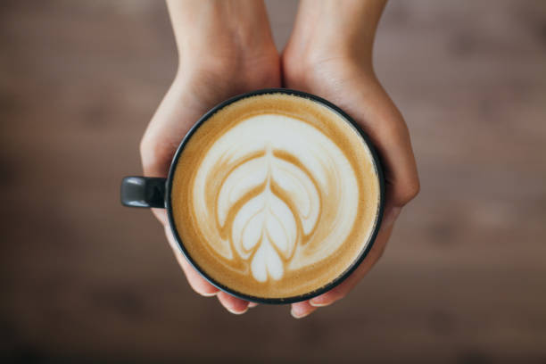 istock Lady's hands holding cup with latte art 803997470
