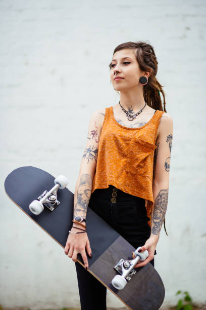 istock Young woman with dreadlocks and tattoos, with skateboard 804017320