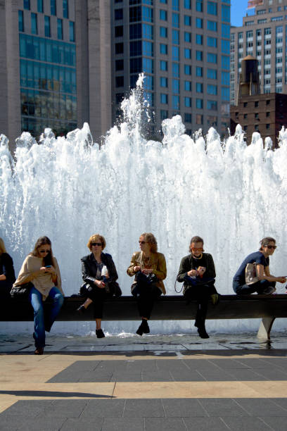 Urban Cultural Life, New York City, USA. Women waiting for a matinee performance outside Lincoln Center, Upper West Side, Manhattan. New York City, USA - October 15, 2016: Five women are seen sitting at a decorative water fountain as they wait for an afternoon matinee music or arts performances at Lincoln Center, Upper West Side of Manhattan. columbus avenue stock pictures, royalty-free photos & images