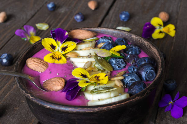 istock Smoothie bowl with fresh berries, nuts, seeds and summer flowers 804025252
