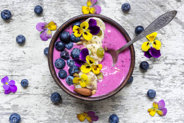 istock Smoothie bowl with fresh berries, nuts, seeds and summer flowers 804025596