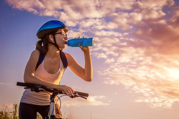 istock Young bicyclist drinking water on the field 804033306