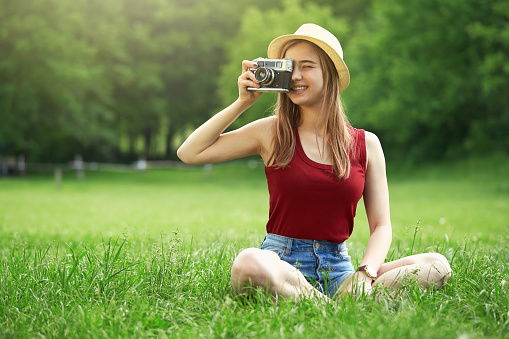 cute girl with camera on grass summer green