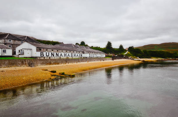 bunnahabhain destillerie fabrik aus dem meer, islay, vereinigtes königreich - bruichladdich whisky stock-fotos und bilder