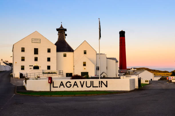 lagavulin brennerei fabrik nach sonnenuntergang, islay, vereinigtes königreich - bruichladdich whisky stock-fotos und bilder