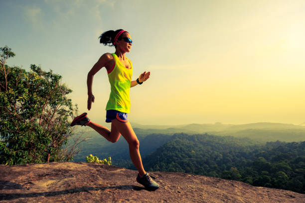 istock Young woman running on mountain top rock 804061390