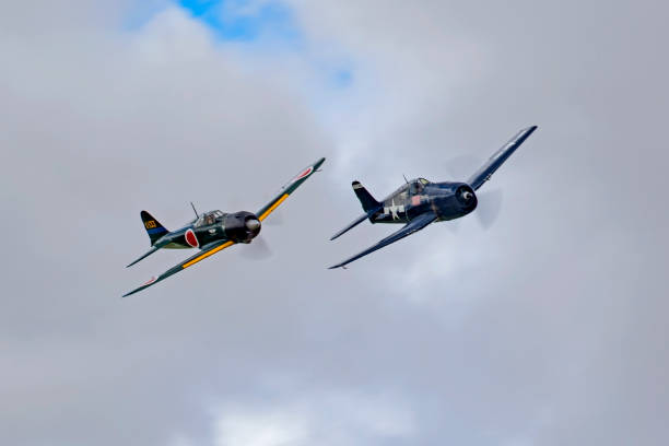 avion avions wwii f-6f hellcat et mitsubishi zéro pendant un air show lutte aérienne chien - fighter plane photos et images de collection