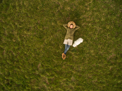 Aerial view of a woman and her white Maltese dog,taken with drone