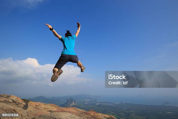 Young Woman Jumping On Mountain Peak Stock Photo - Download Image Now - Achievement, Adult, Adults Only