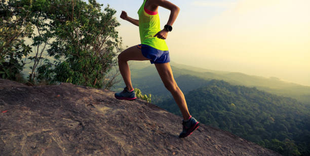 istock Young woman running on mountain top rock 804087624