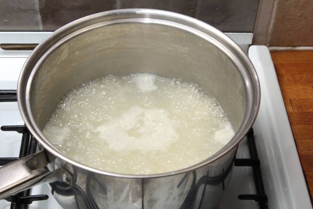 cacerola de arroz en agua hirviendo sobre una encimera de gas - hervido fotografías e imágenes de stock