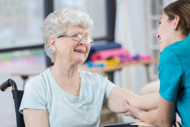 istock Senior woman laughs during painful elbow therapy 804095714