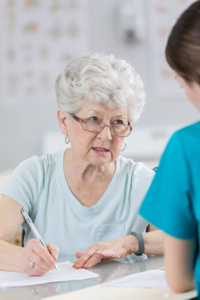 istock Senior woman discusses intake forms with physical therapist 804095744