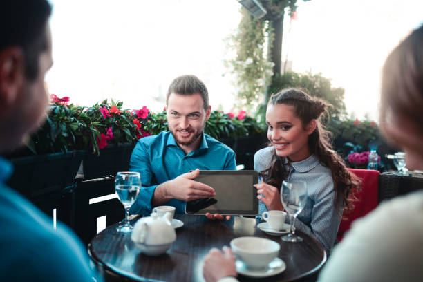 istock Young Man Showing on Tablet to his Friends in Cafe 804098096