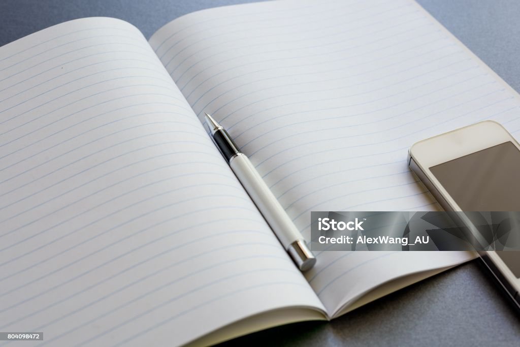 Notebook Open. Phone An Opened Notebook With A Pen And Mobile Phone On Dark Grey Background ...