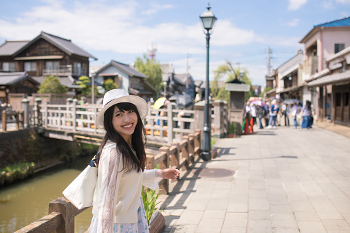 Happy young woman walking in old Japanese town