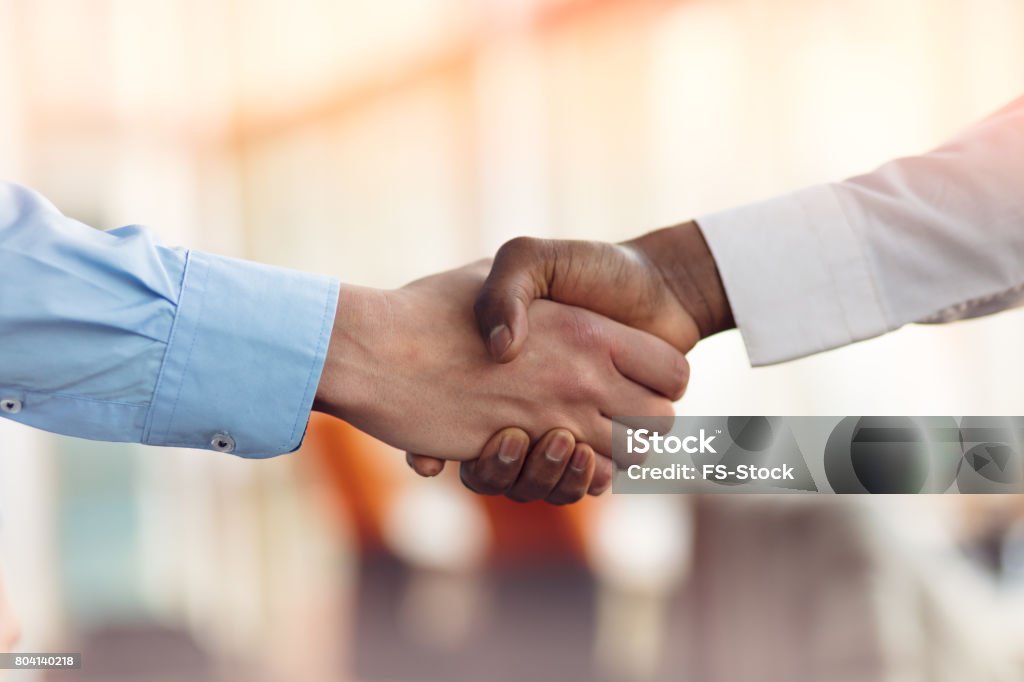 Handshake zwischen Afrika und europäischer Abstammung Mann - Lizenzfrei Abmachung Stock-Foto