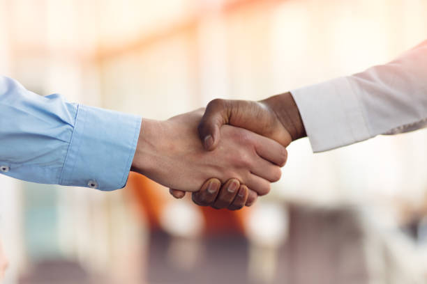 handshake between african and a caucasian man - apertar a mão imagens e fotografias de stock