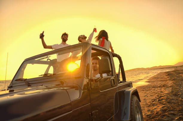 istock Five young people having fun in convertible car at the beach at sunset. 804143032