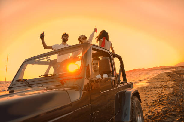 istock Five young people having fun in convertible car at the beach at sunset. 804143190