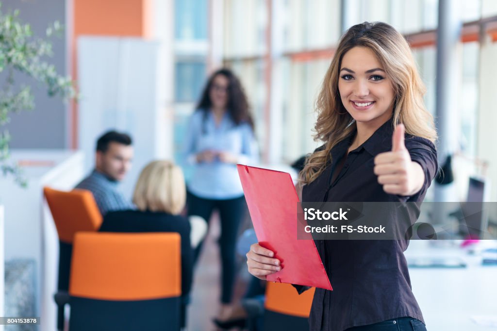 portrait of young business woman at modern startup office interior showing thumbs up portrait of young business woman at modern startup office interior showing thumbs up. Quality Stock Photo