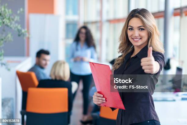 Portrait Of Young Business Woman At Modern Startup Office Interior Showing Thumbs Up Stock Photo - Download Image Now