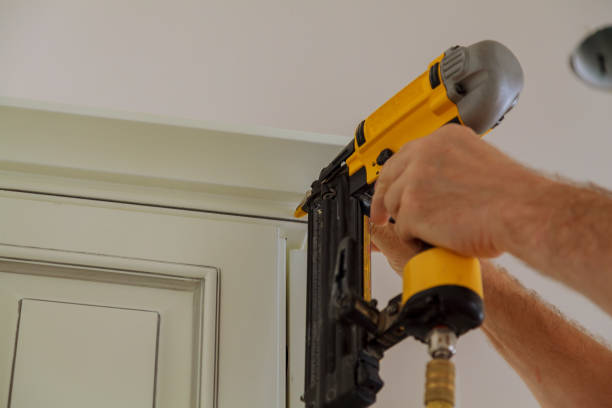 istock Carpenter brad using nail gun to Crown Moulding on kitchen cabinets framing trim, 804157160