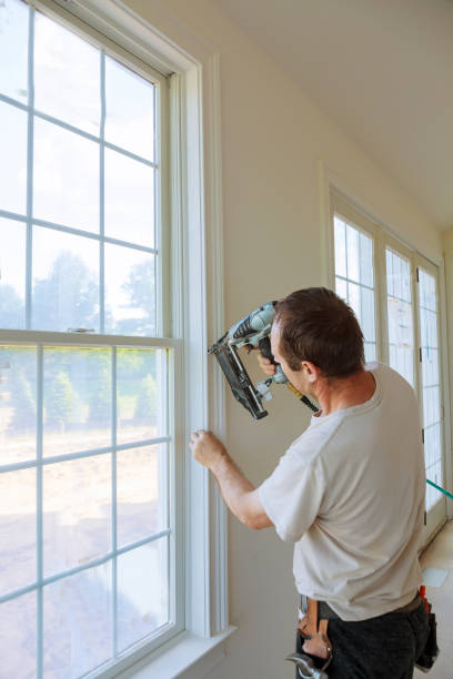 istock Carpenter brad using nail gun to moldings on windows, framing trim, 804159794