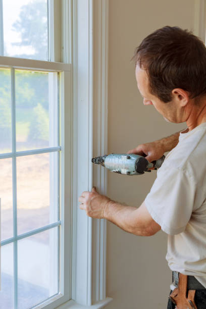 istock Carpenter brad using nail gun to moldings on windows, framing trim, 804159830