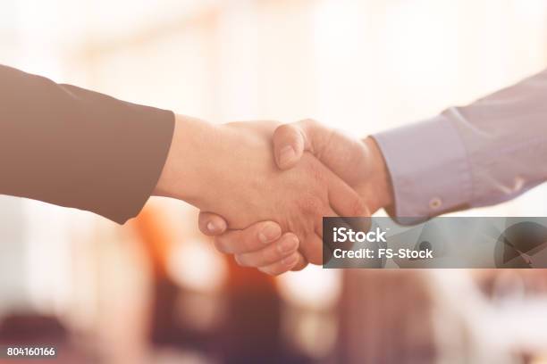 People At Work Man And Woman Hand Shaking At A Meeting Stock Photo - Download Image Now