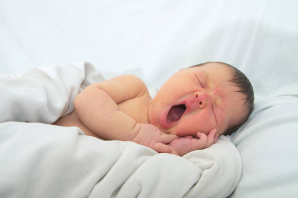 смешное лицо ребенка, новорожденный с желтухой на белом одеяле, детское здравоохранение - yellowing стоковые фото и изображения