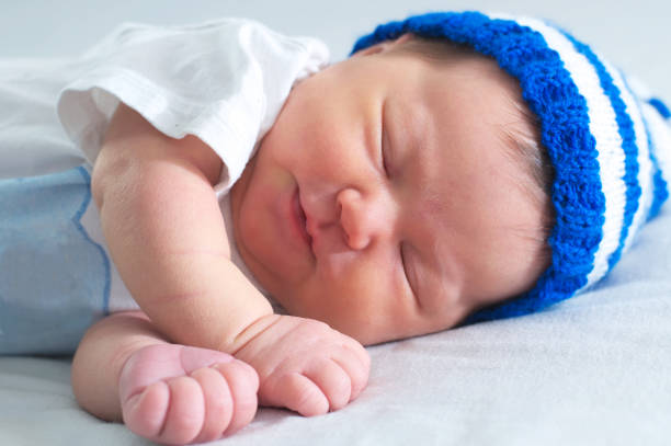 istock funny baby face, sleeping newborn in hat on white blanket 804163344