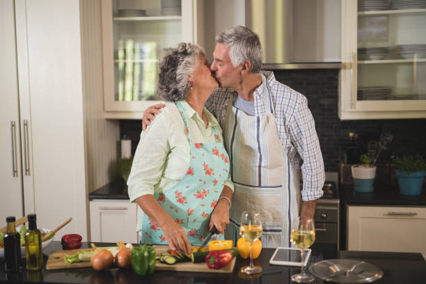 istock Senior couple kissing while preparing food in kitchen 804168412