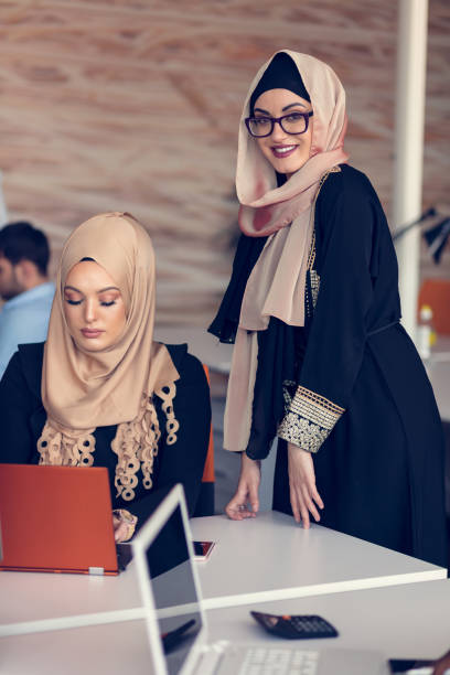 istock Two woman with hijab working on laptop in office. 804171394
