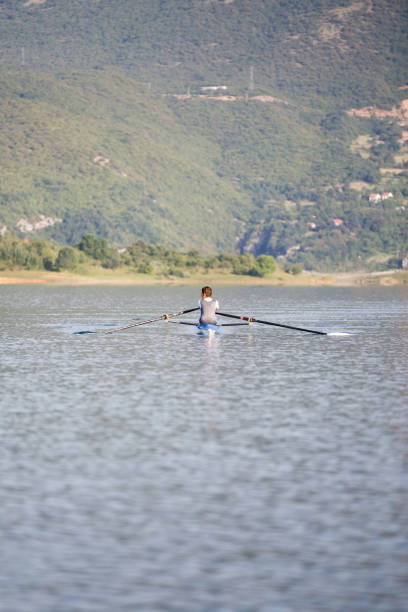 istock A Young single scull rowing competitor paddles on the tranquil lake 804175596