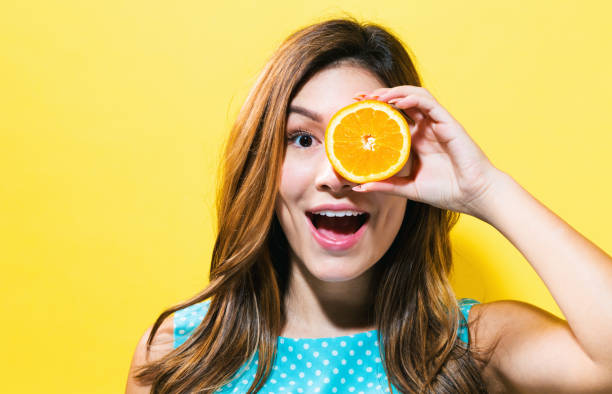 Happy young woman holding oranges