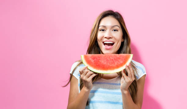 istock Happy young woman holding watermelon 804178176