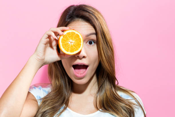 istock Happy young woman holding orange 804178186