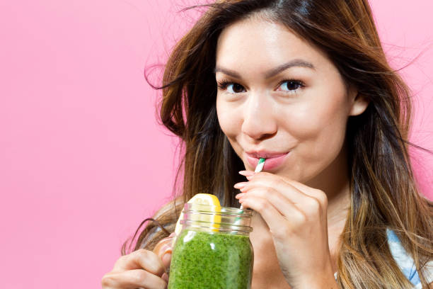 istock Happy young woman drinking smoothie 804178218