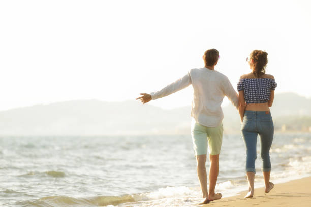 istock happy couple waling on the beach and having fun 804196616