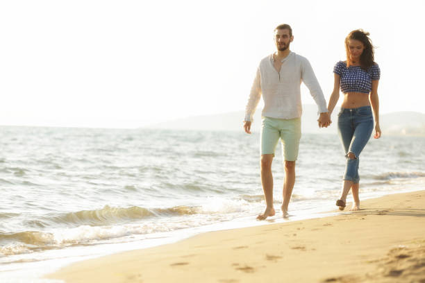 istock happy couple waling on the beach and having fun 804215650