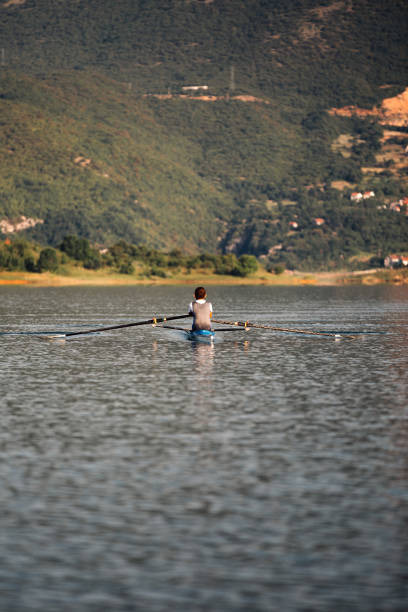 istock A Young single scull rowing competitor paddles on the tranquil lake 804229270