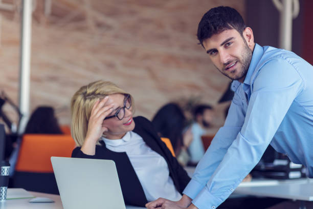 istock Colleagues chatting, sitting together at office table, smiling 804234948