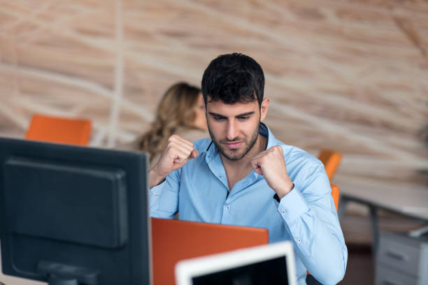 istock happy young business man working on desktop computer at his desk in modern bright startup office interior 804235092