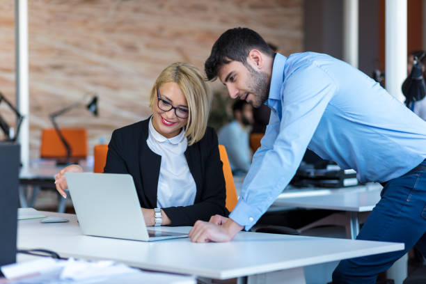 istock Colleagues chatting, sitting together at office table, smiling 804237374