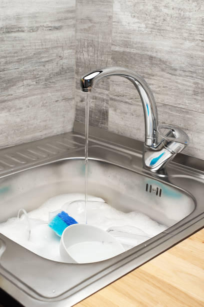 istock Kitchen sink with water, foam, tableware, blue cleaning sponge 804250178