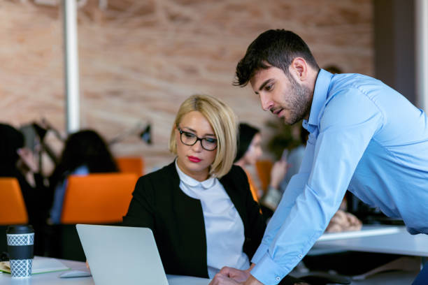 istock Colleagues chatting, sitting together at office table, smiling 804271850