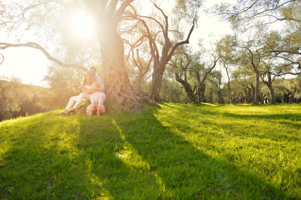 istock couple relax under the tree. Fine art style. Olive garden. 804275640