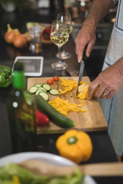 istock Mid section on man cutting yellow bell pepper in kitchen 804275806